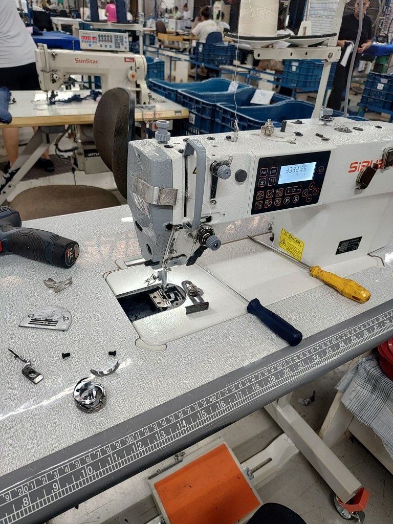Modern industrial sewing machines at Huaxing Apparel factory in Dongguan, China